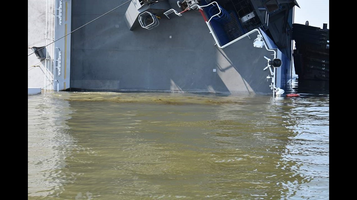 Fire, smoke coming from overturned cargo ship, four missing