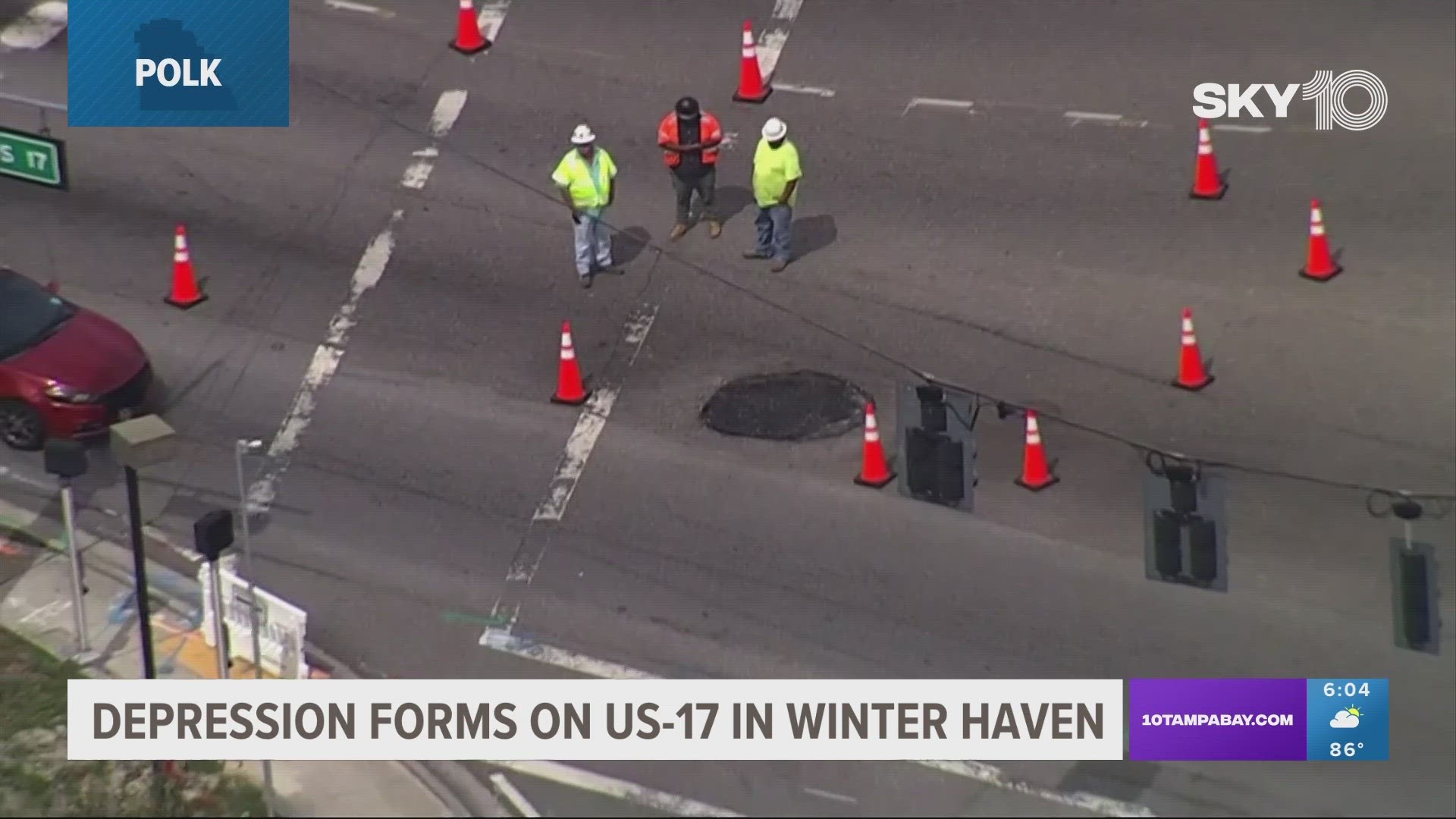 A contractor is looking into the cause of the depression in the roadway.