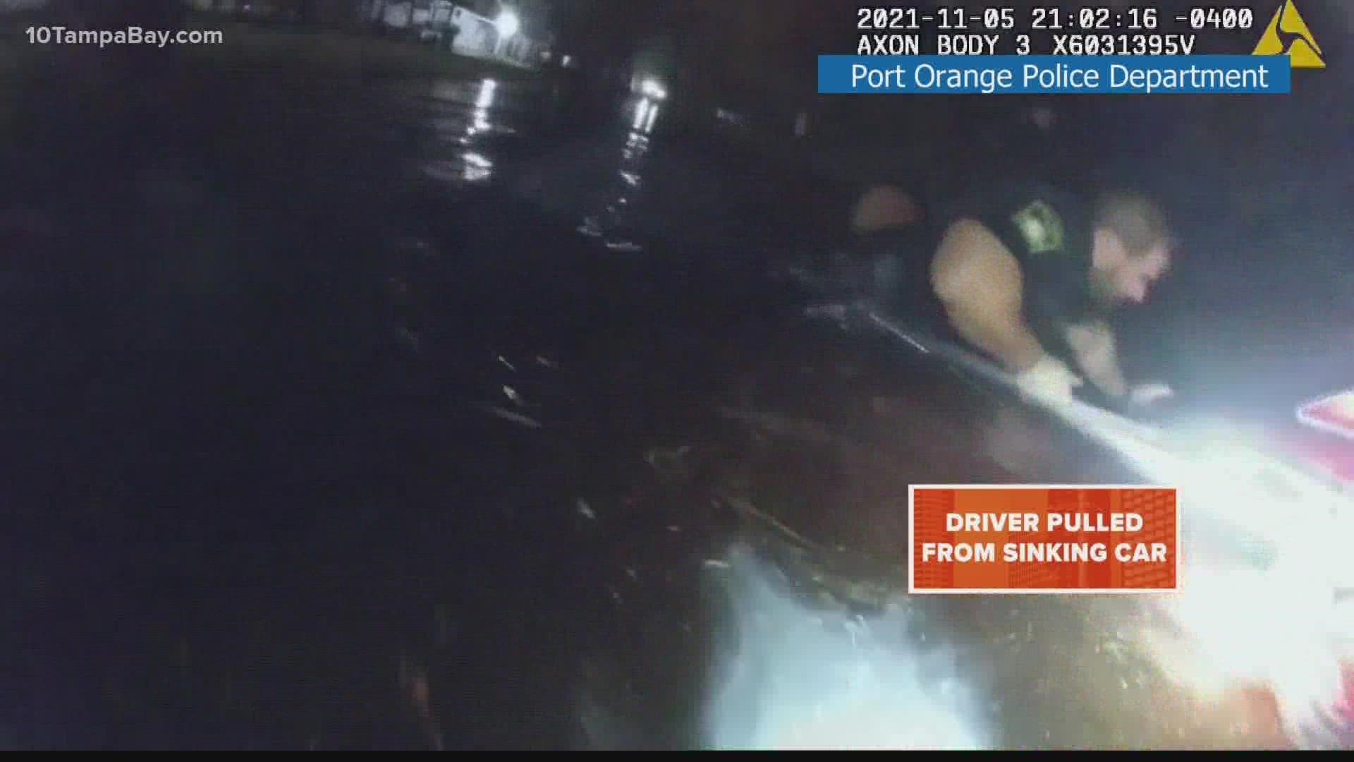 The officers can be seen jumping into the water and shattering a car window in order to pull the woman to safety.