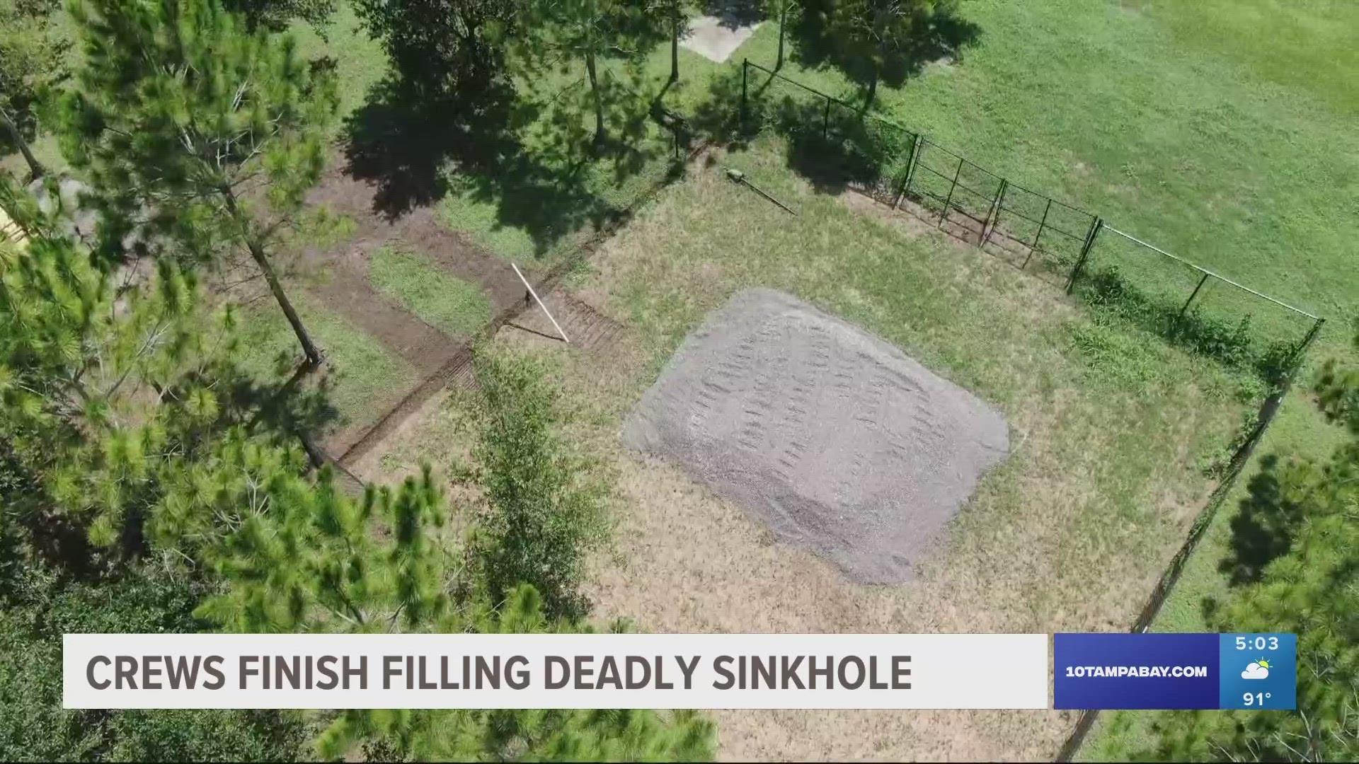 A picture shows the sinkhole, in which the area surrounding it has been fenced, refilled and flattened out at ground level.