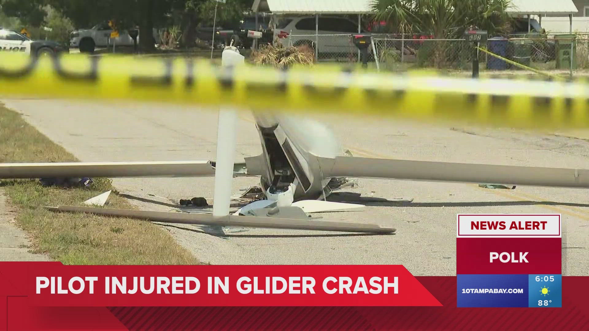 Photos show a small white glider lying upside down across the road with its front end damaged.